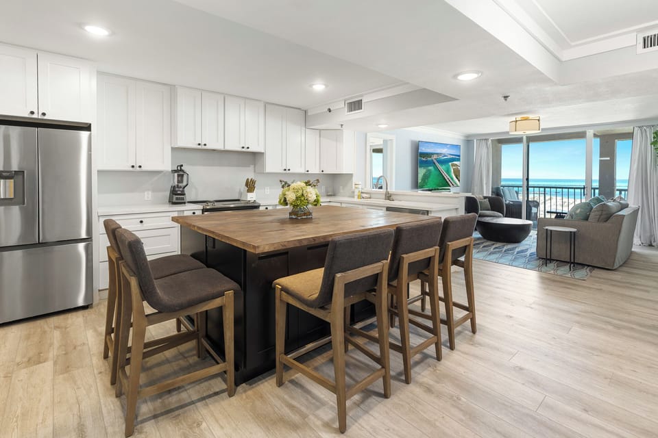 Your open kitchen flows into the living area with ocean views, featuring a spacious island perfect for morning coffee or evening conversations.