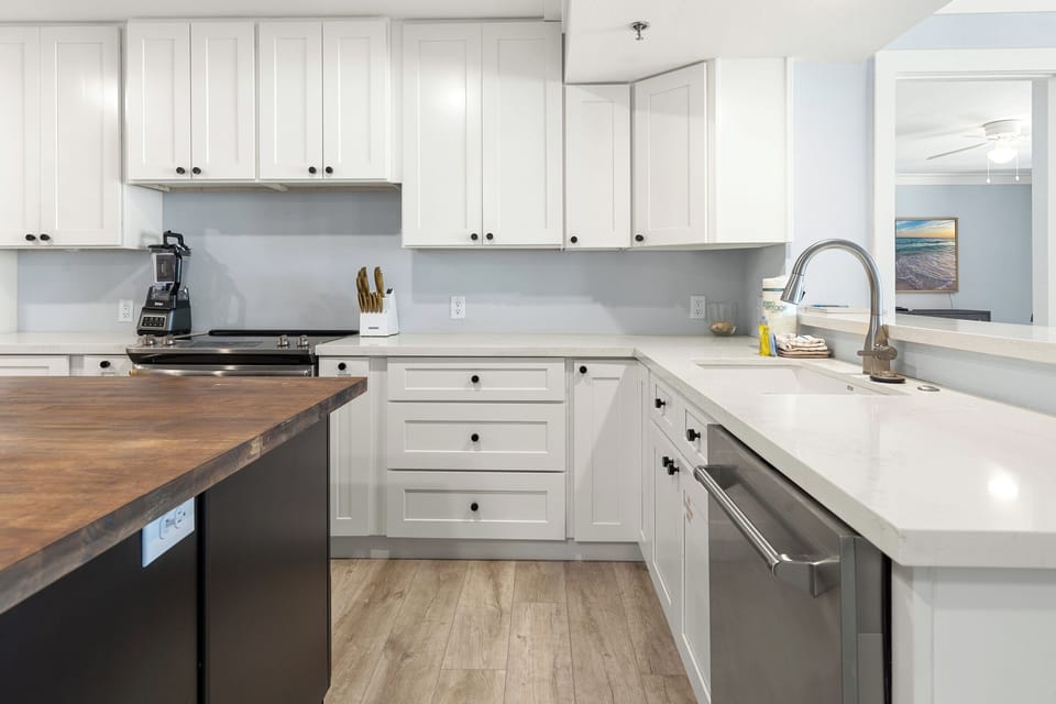 Cook with ease in this bright, fully-equipped kitchen featuring sleek white cabinetry, modern appliances, and ample counter space for your culinary adventures.
