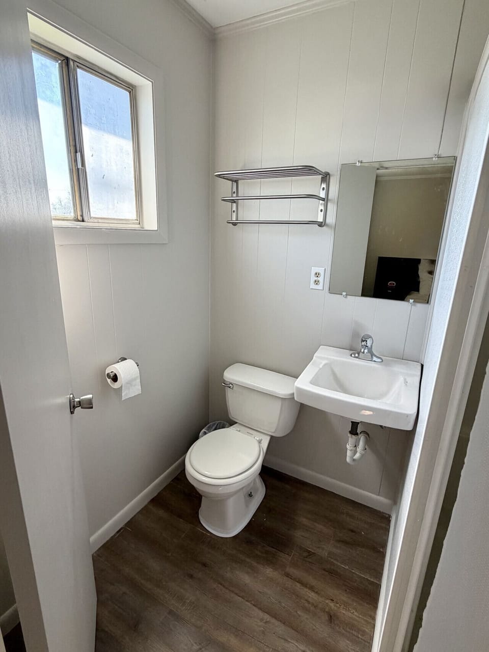 Private bathroom with toilet, sink, and mirror