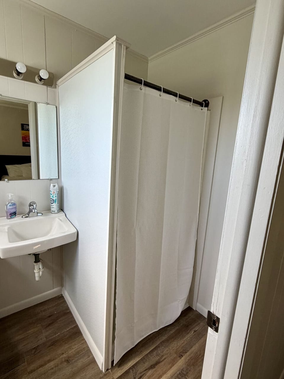 Bathroom shower with curtain and pedestal sink