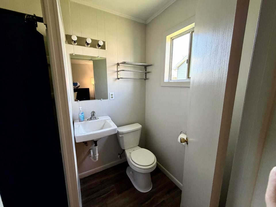 Private bathroom with pedestal sink, vanity mirror, and towel rack