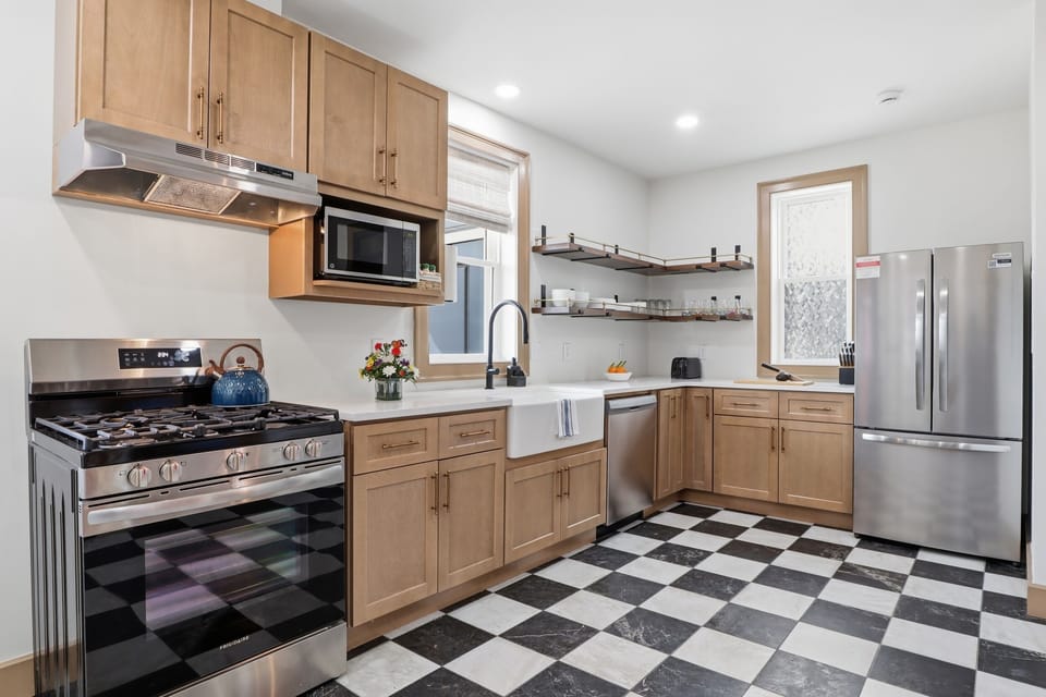 Gas range, farmhouse sink, checkerboard floors, and enough counter space to feed 12 — this kitchen was designed to actually be used, not just photographed.