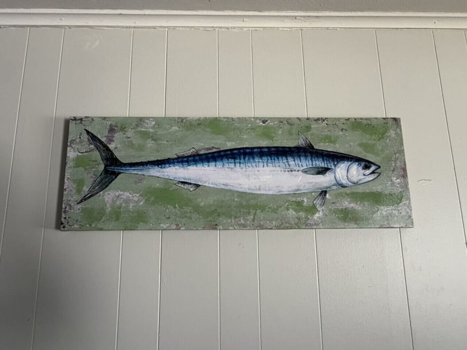 Framed vintage-style fish art on weathered green wood — a signature Lake Erie angling touch