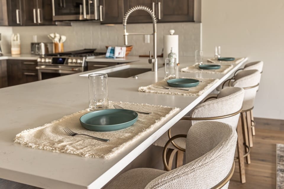 Your modern kitchen island awaits with stylish seating and elegant place settings, perfect for sharing meals together.