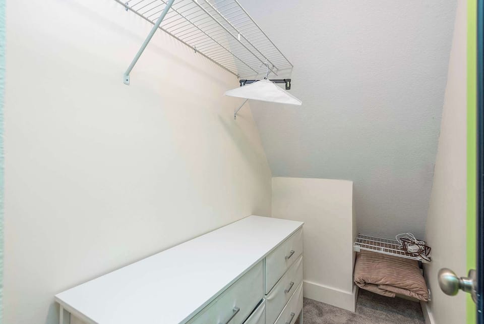 Keep your belongings tidy and out of sight during your stay. This convenient walk-in storage area features a full dresser and sturdy wire shelving, providing ample space for suitcases, clothing, and gear.