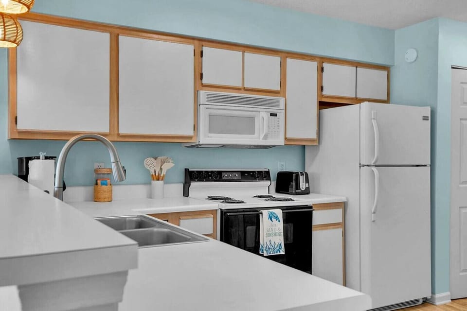 Cook, snack, and gather with ease in this bright, fully equipped kitchen featuring everything you need for a comfortable stay. With ample counter space, full-size appliances, and all the essentials for preparing family meals, beach snacks, or morning coff