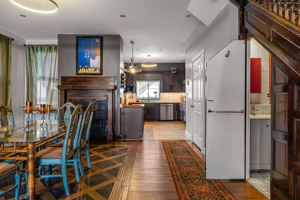 The full center of the home: dining room, fireplace, Café Arabica art, kitchen beyond — and the Harry Potter Potty door just visible on the right.