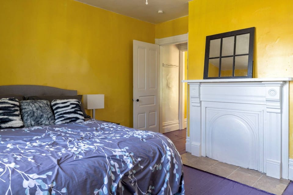 Decorative white mantel in the bedroom with a black-framed mirror on top, adding character to the space.
