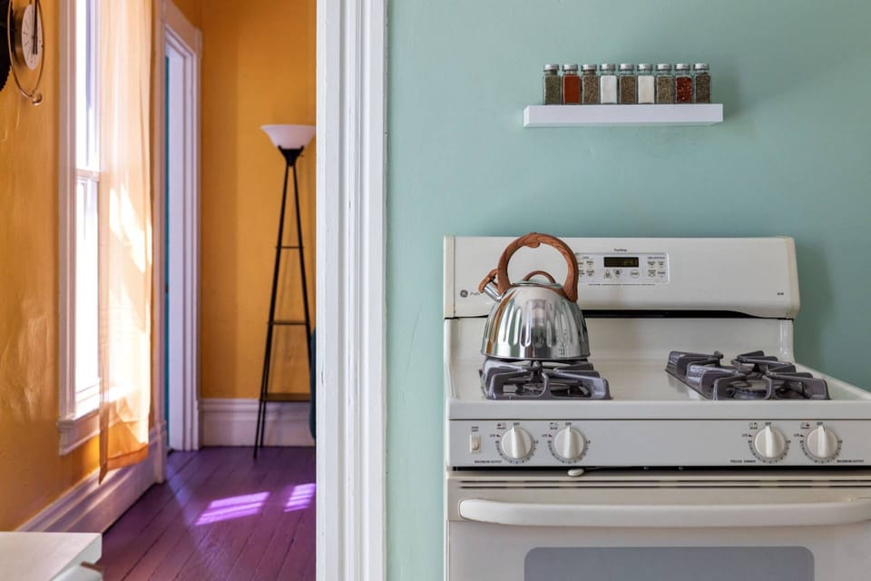 Kitchen opens directly off the living room, with a gas stove, kettle, and spice shelf ready to go.