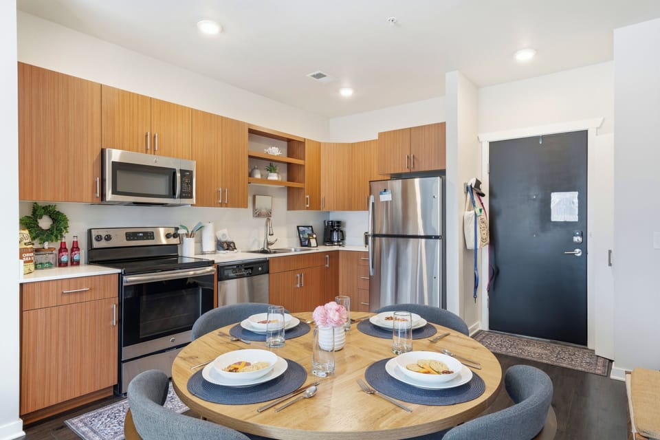 Modern kitchen fully equipped with stainless steel appliances and a cozy dining table for four.