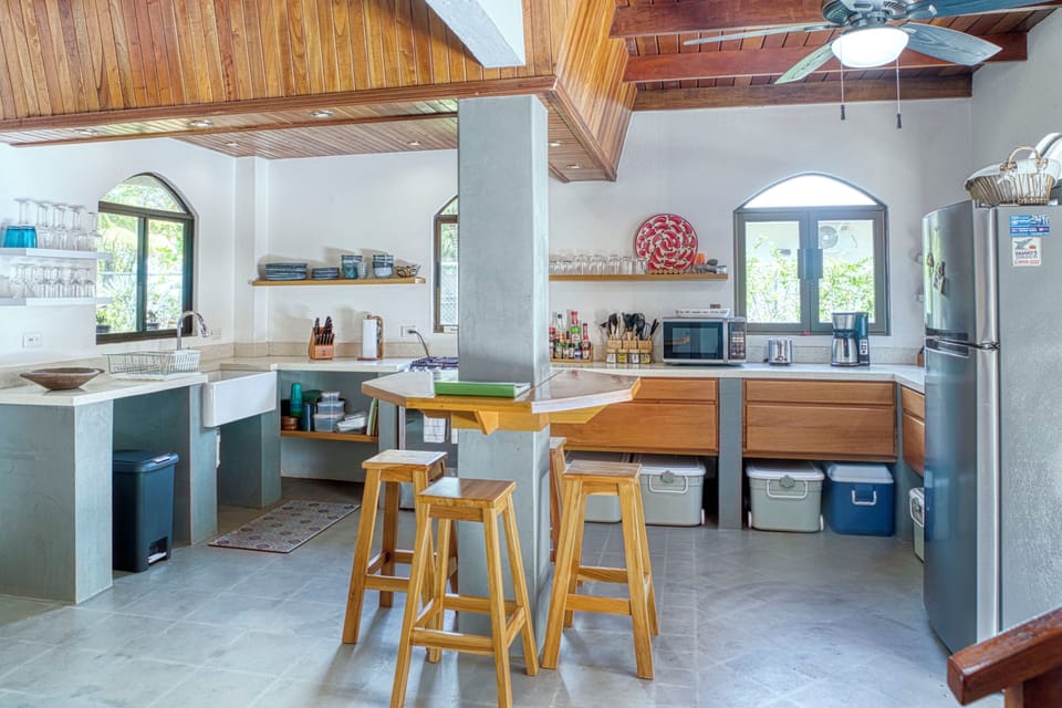 Modern kitchen with exotic wood ceilings and a cozy breakfast bar for a tropical