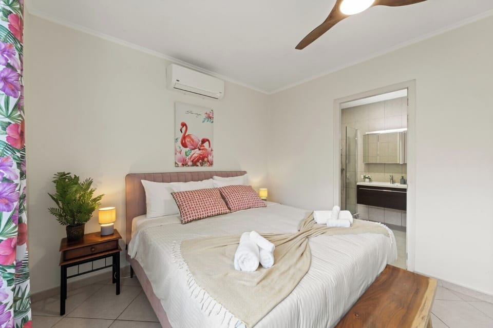 Spacious bedroom with king bed, en-suite access and ceiling fan for added comfort