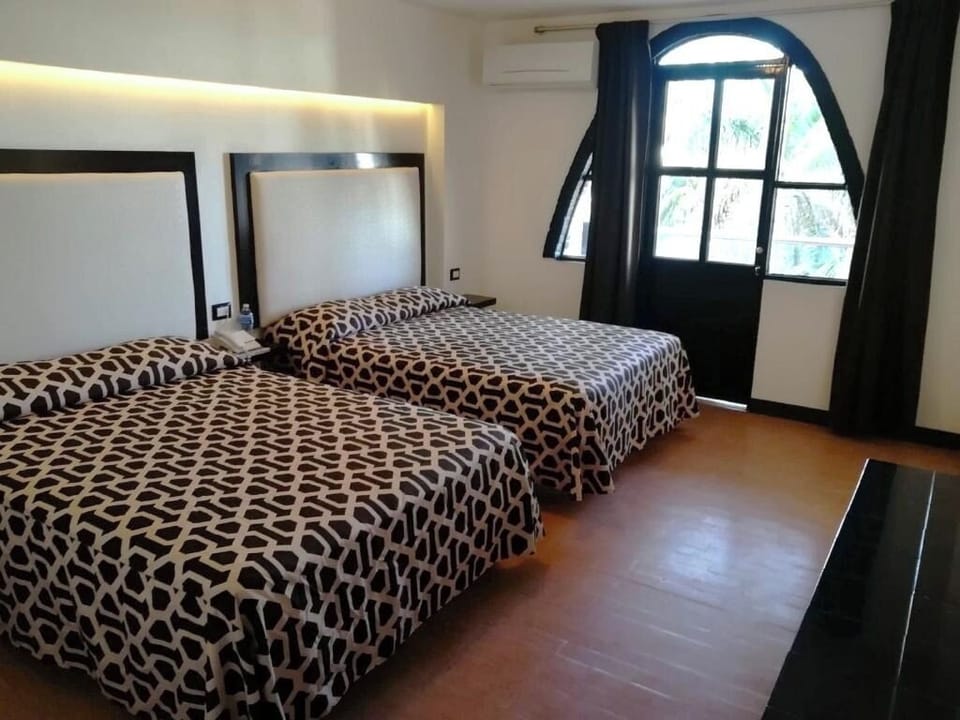 Wake up to daylight by the arched window beside cozy beds.