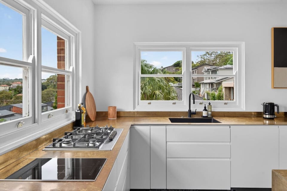 Spacious kitchen equipped with modern appliances, including a five-burner gas cooktop, a two-burner electric cooktop, dual dishwashers, and everything you need to cook comfortably at home.