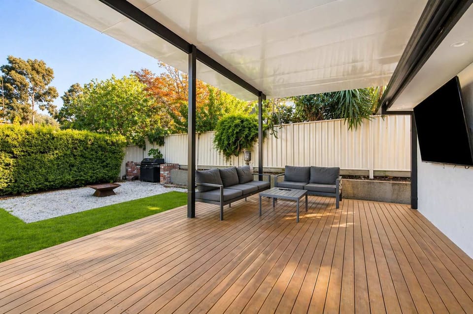 Covered outdoor deck with BBQ, fire pit and TV.