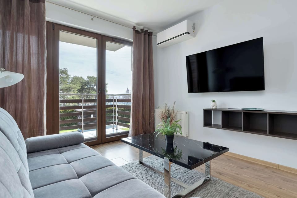 A comfortable lounge area with a sofa, coffee table, and decorative elements. The room is styled in neutral tones with a relaxing atmosphere.