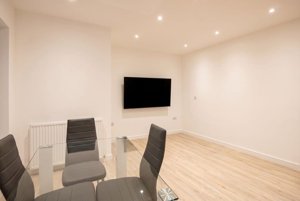 Open living and dining space with a wall-mounted flat-screen TV for relaxed evenings in.