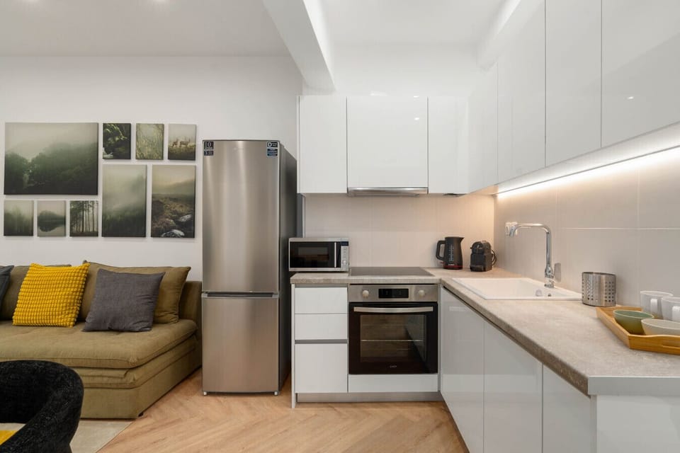Fully equipped kitchen with full-size fridge, oven, microwave, and under-cabinet lighting.
