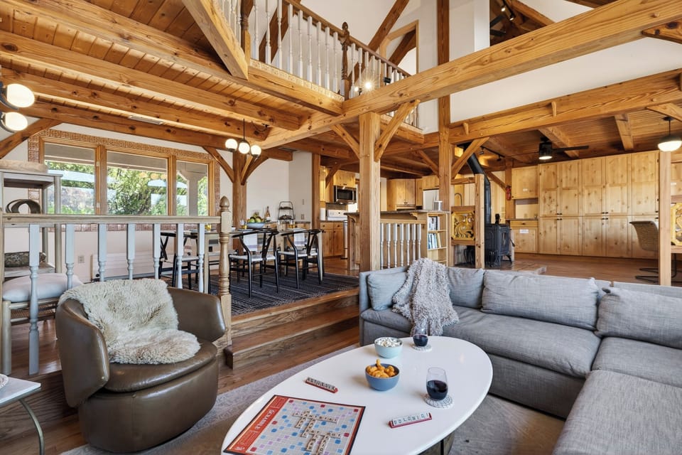 A stunning open-concept living space with soaring wood beams, cozy seating, and seamless flow into the kitchen and dining areas.