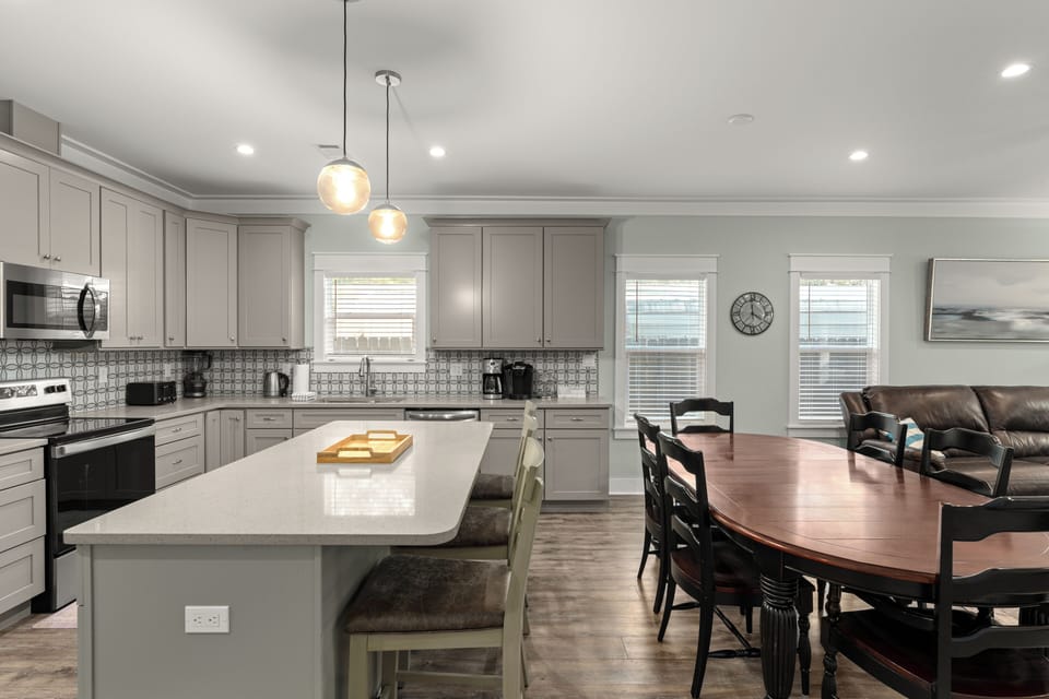 Spacious kitchen with a large island, modern finishes, and a dining table perfect for group meals.