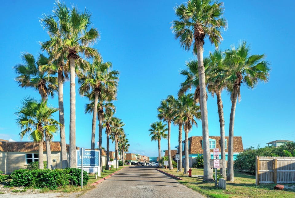 Palm-lined entrance welcoming you into a laid-back coastal community just steps from the beach.