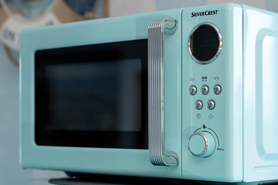 A close-up of a microwave in matching pastel tones on the kitchen counter.