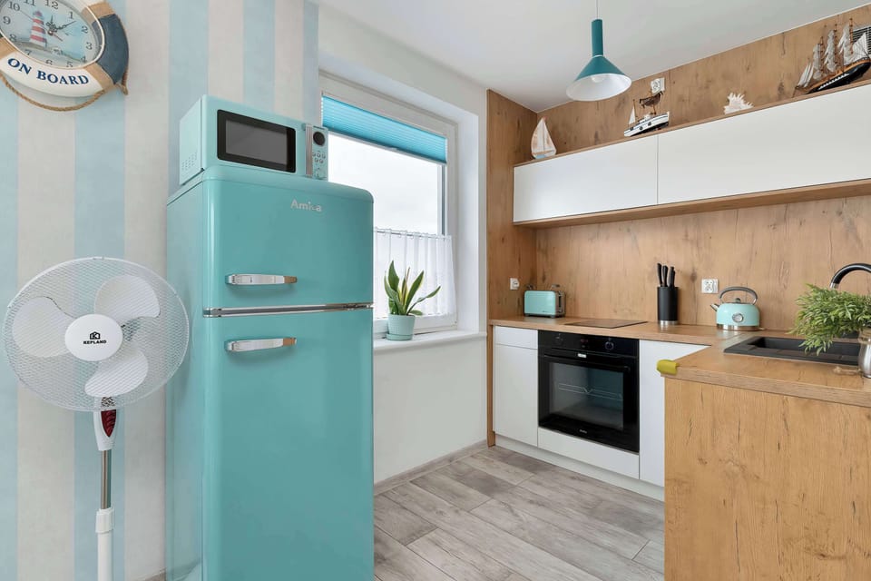 A retro-style fridge in pastel color placed beside the kitchen, adding character.