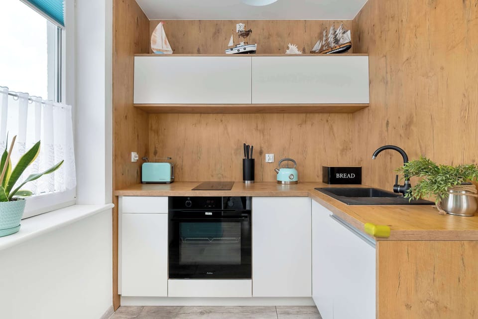 A compact kitchen with wooden cabinetry, built-in appliances, and a clean, contemporary design.