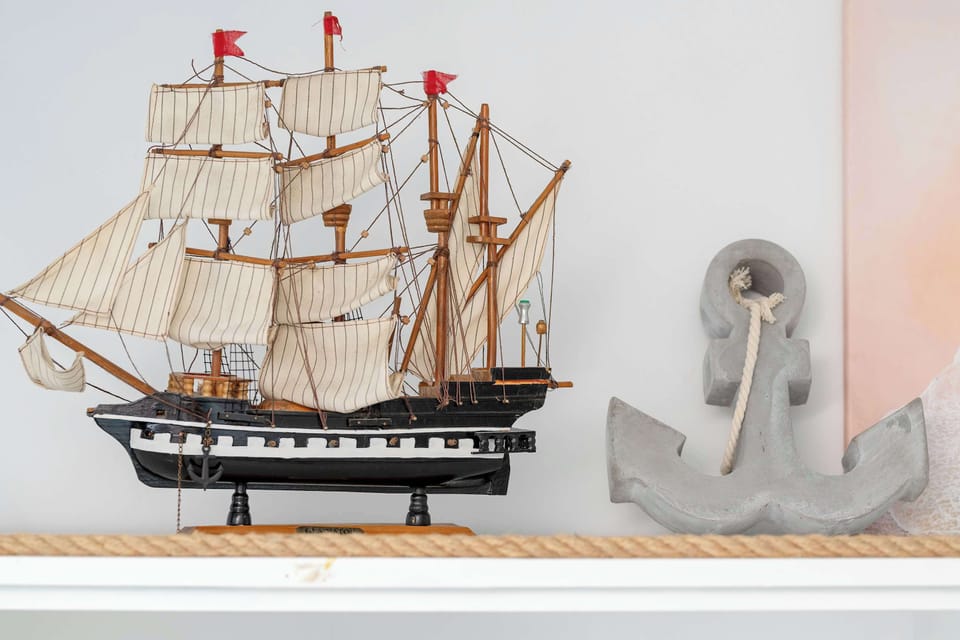 A decorative model ship displayed on a shelf, contributing to the coastal-inspired theme.