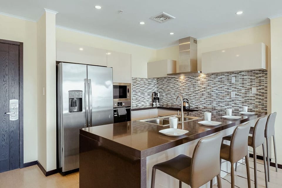 Fully equipped kitchen with breakfast bar seating—ideal for quick meals or casual dining.