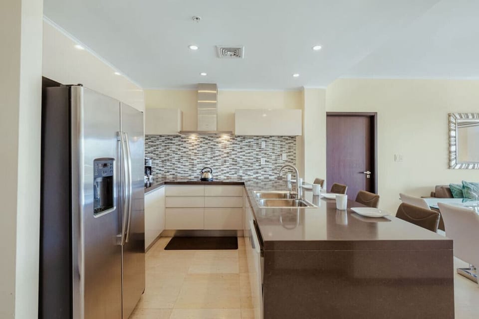 Modern kitchen with ample counter space and bar seating—great for prepping meals and staying connected with the group.