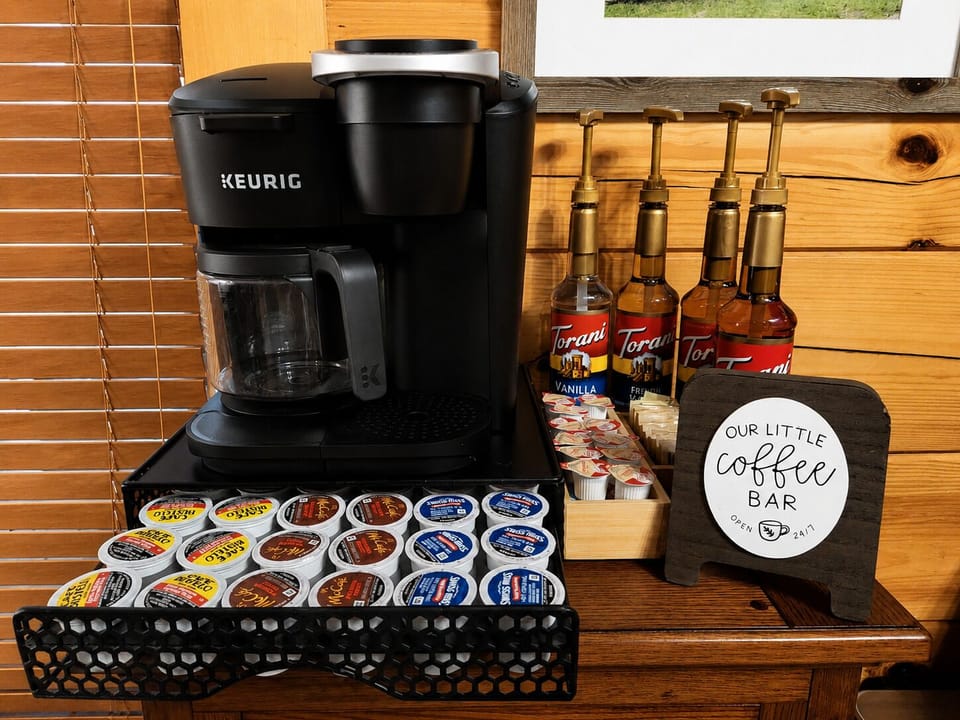 Your morning coffee bar — Keurig duo, Torani syrups, ground coffee, various coffee pods, hot chocolate, cream and sugars! ☕