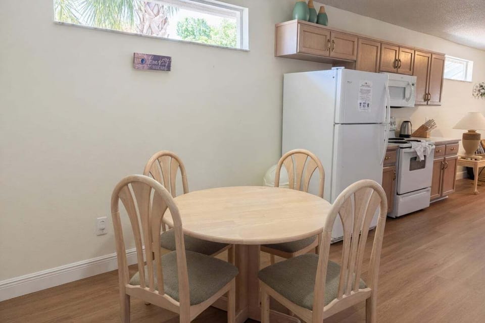 Bright dining space with a round table and seating for 6. Open layout connects to the fully equipped kitchen, perfect for family meals.