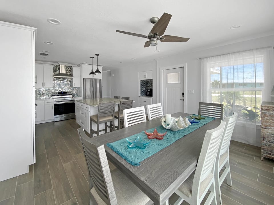 Modern kitchen and dining area with island seating and natural light.