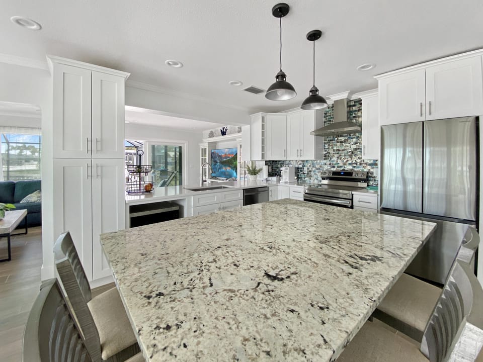 Modern kitchen with granite island and stainless steel appliances, perfect for entertaining.