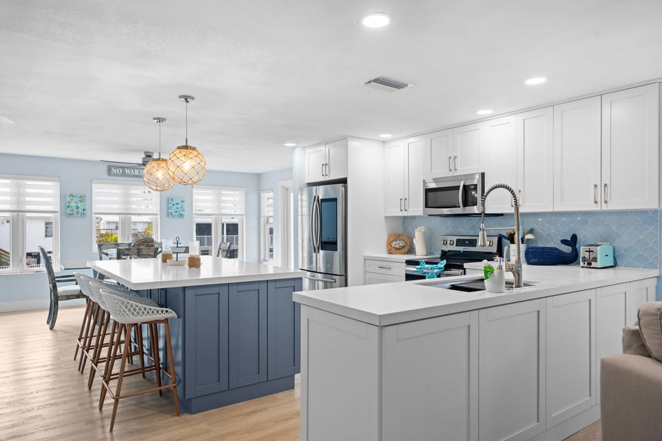 Two full counter areas mean nobody is fighting for prep space. Scallop tile backsplash and stainless appliances throughout.