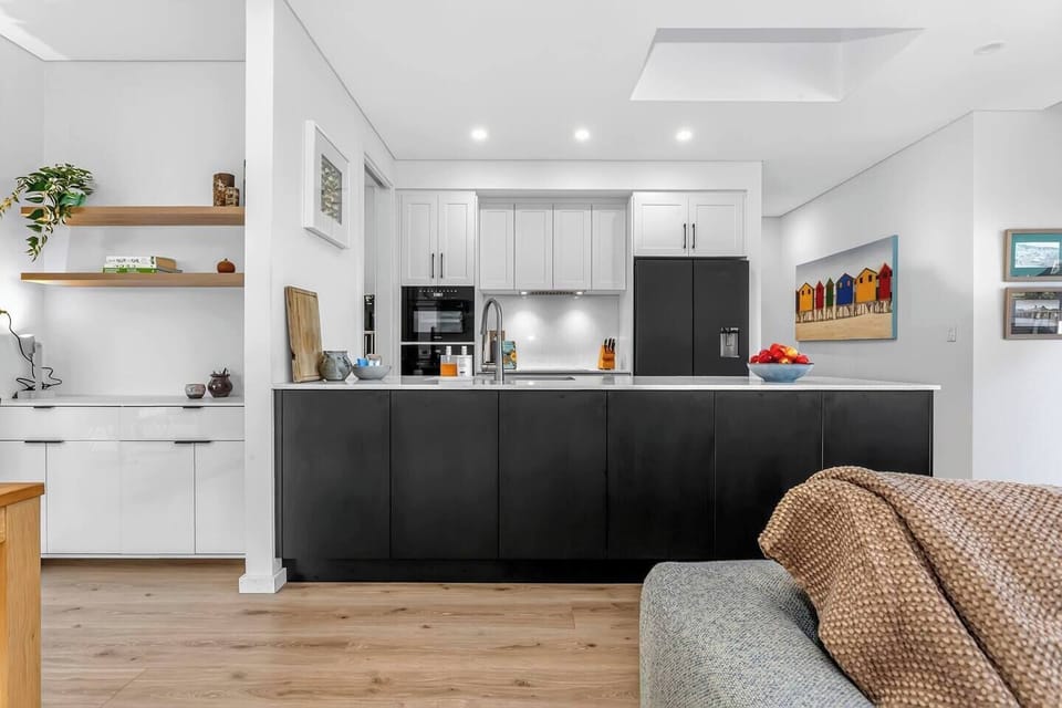 Gather around the generous island bench, where ample prep space and a sleek layout make cooking feel social and effortless.