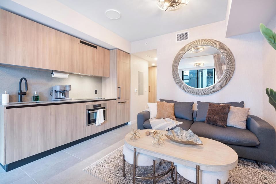 Modern kitchen and living area with wood cabinetry and a cozy sofa.