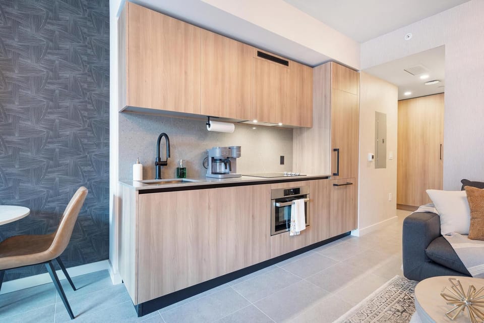 Modern kitchen with wood cabinetry and integrated appliances for a streamlined look.