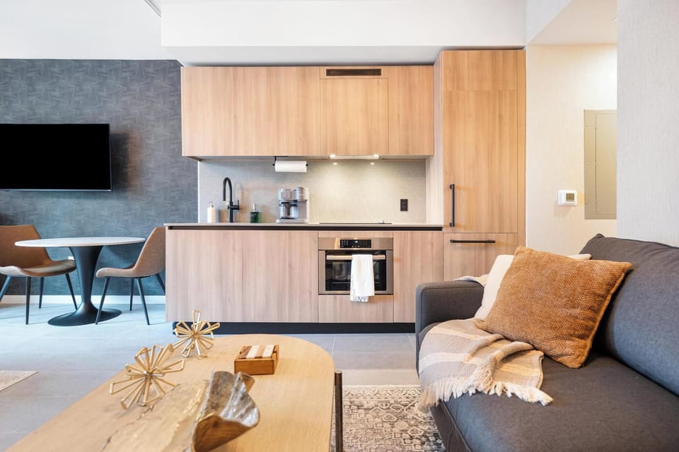 Modern kitchen with wood cabinetry and a cozy living area for relaxing.