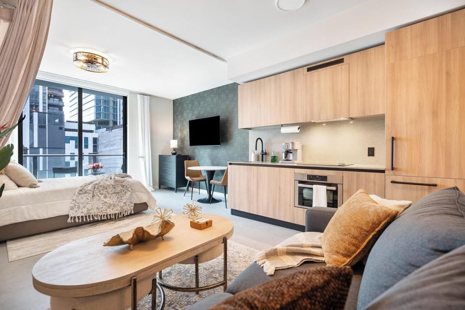 Modern studio apartment with a fully equipped kitchen and city views from the balcony.
