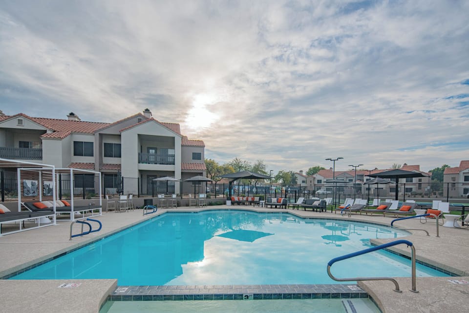 Pool and hottub with lounges nearby. 