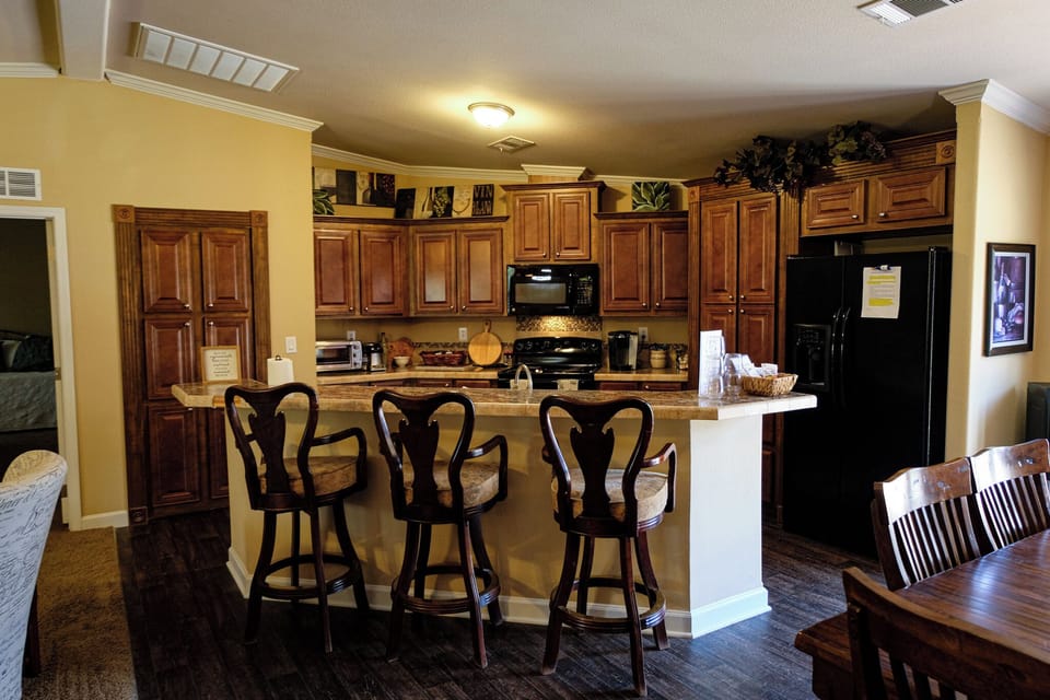 Spacious kitchen with breakfast bar seating and rich wood finishes