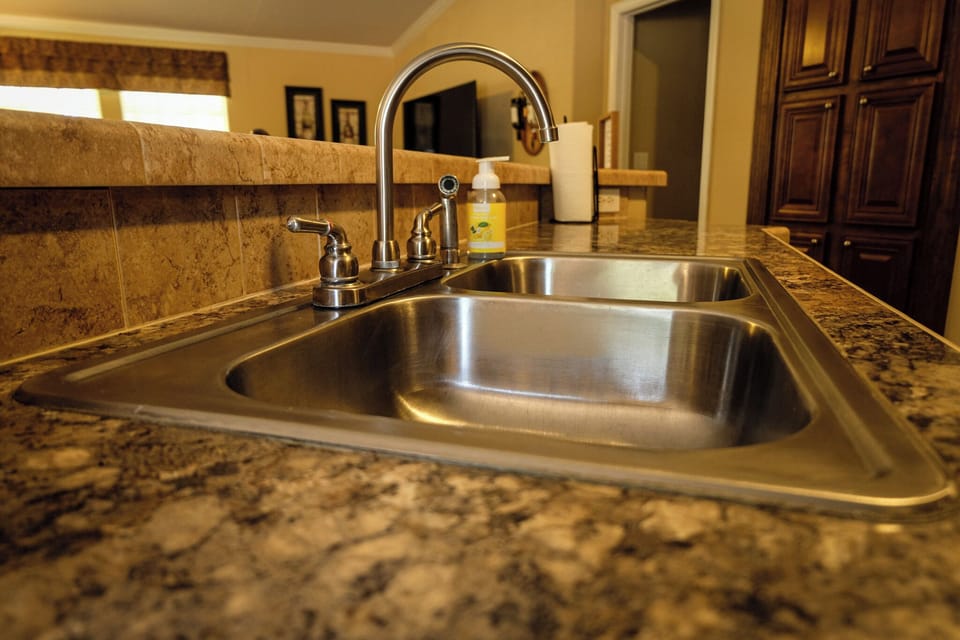 Spacious double sink with granite counters and warm kitchen finishes