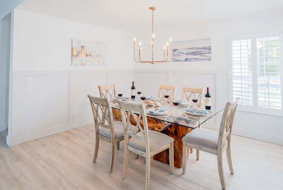 Dinner together just got an upgrade — a glass-top dining table for eight, gold chandelier, and a room bright enough to make every meal feel like a special occasion.