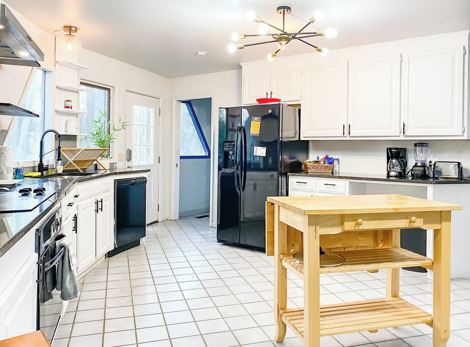The kitchen’s geometric layout mirrors the home’s unique design, offering plenty of space to cook, gather, and move comfortably within this one-of-a-kind setting.