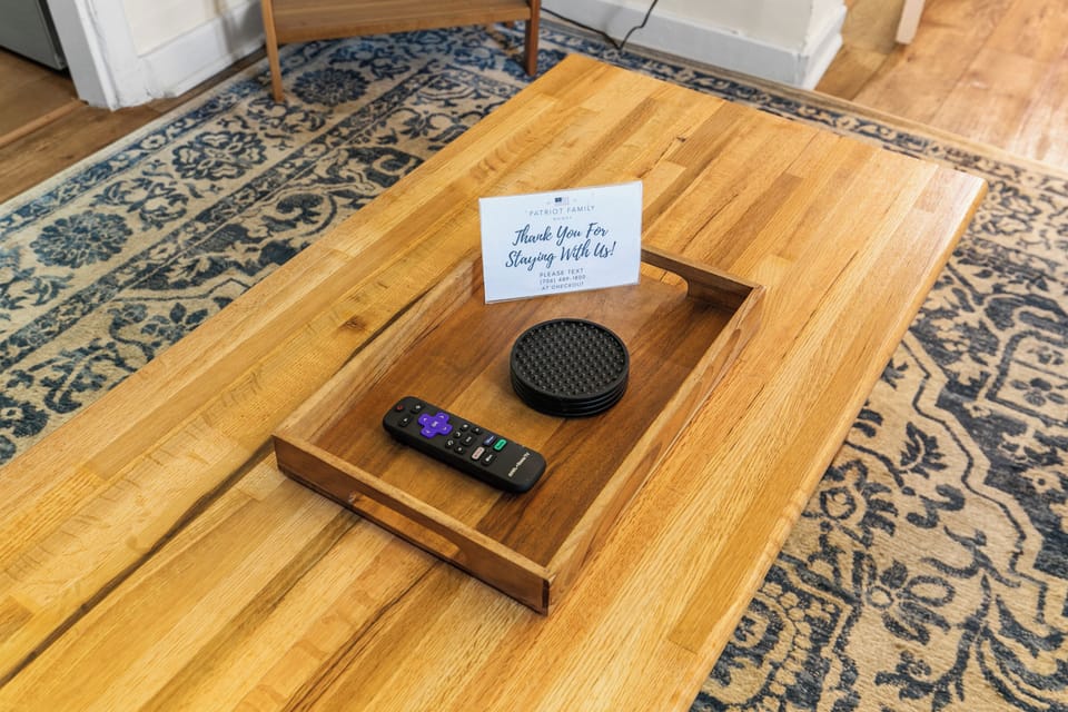 A closer look at the living room details—wooden coffee table, simple accents, and a Roku remote ready for an easy night in.