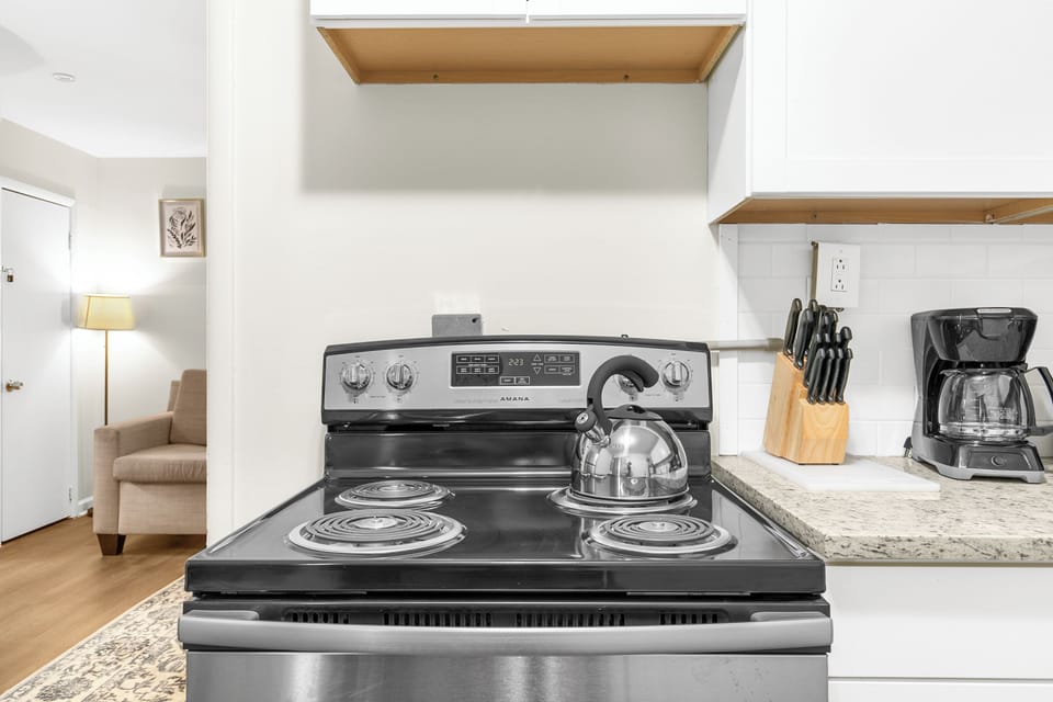 The kitchen is set up for easy use, with a full stove, oven, and coffee maker—open to the living area so everything feels connected.