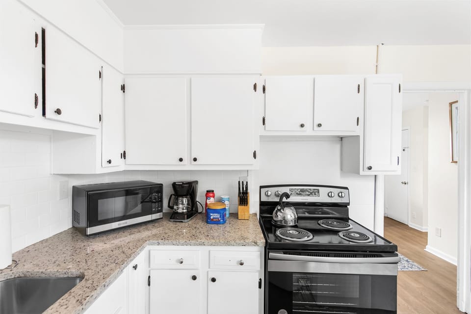 The kitchen is set up for easy use, with a full stove, oven, and coffee maker—open to the living area so everything feels connected.