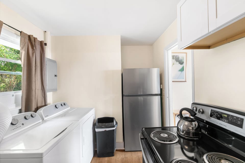 Pulling back for a full view of the laundry area placed inside the kitchen for longer-term guests.